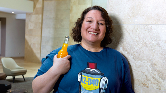 Eine Frau im T-Shirt mit Softdrink in der Hand